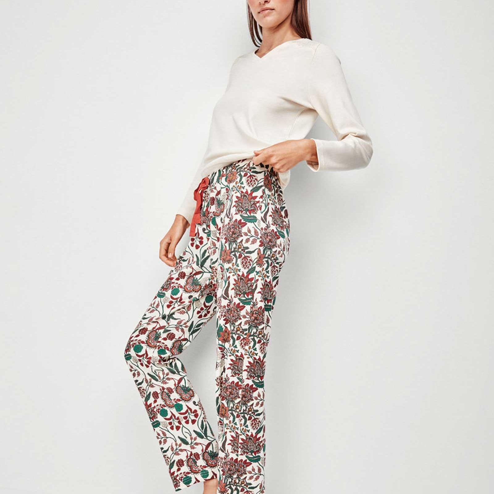 Pigiama composto da maglietta semplice con scollo a V e pantaloni il tutto stampato con motivi floreali molto colorati su fondo chiaro. Un basic molto comodo e femminile. Composizione: 85% poliestere e 15% poliammide