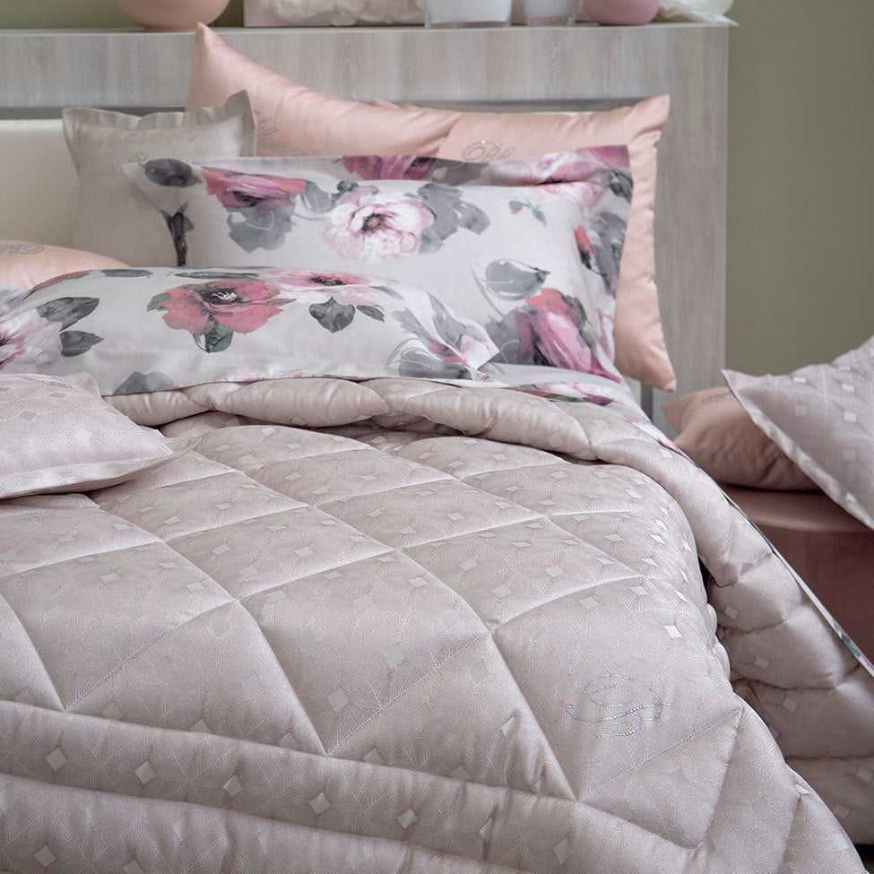 Calda trapunta matrimoniale con moderno disegno jacquard e logo Blumarine in cristalli. Misure: 270x265 cm Tessuto sopra: 100% poliestere jacquard tinto in filo Tessuto sotto: 100% cotone Imbottitura: 100% poliestere 340 g/mq Made in Italy Codice: 72619 I