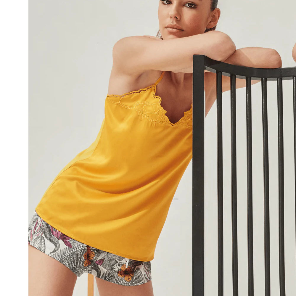 Pigiama corto Gisela. Top bretella in ocra in raso sul davanti e maglina sul retro. Scollo a v con ricami sul bordo. Pantaloncino in raso a fantasia con laccetto. Composizione: 97% PES - 3% EA / 50% CO - 50% MD / 97% PES - 3% EA Colore: Ocra - Fantasia Co