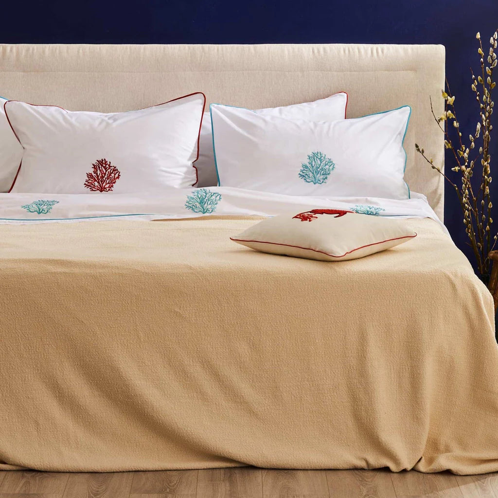 Il Completo Lenzuola Matrimoniale Aka è realizzato in Percalle di Cotone 200TC e caratterizzato dal ricamo di coralli sulle federe e sulla balza del lenzuolo da sopra. Il lenzuolo da sotto con angoli è bianco tinta unita e le federe sono rifinite da un pi