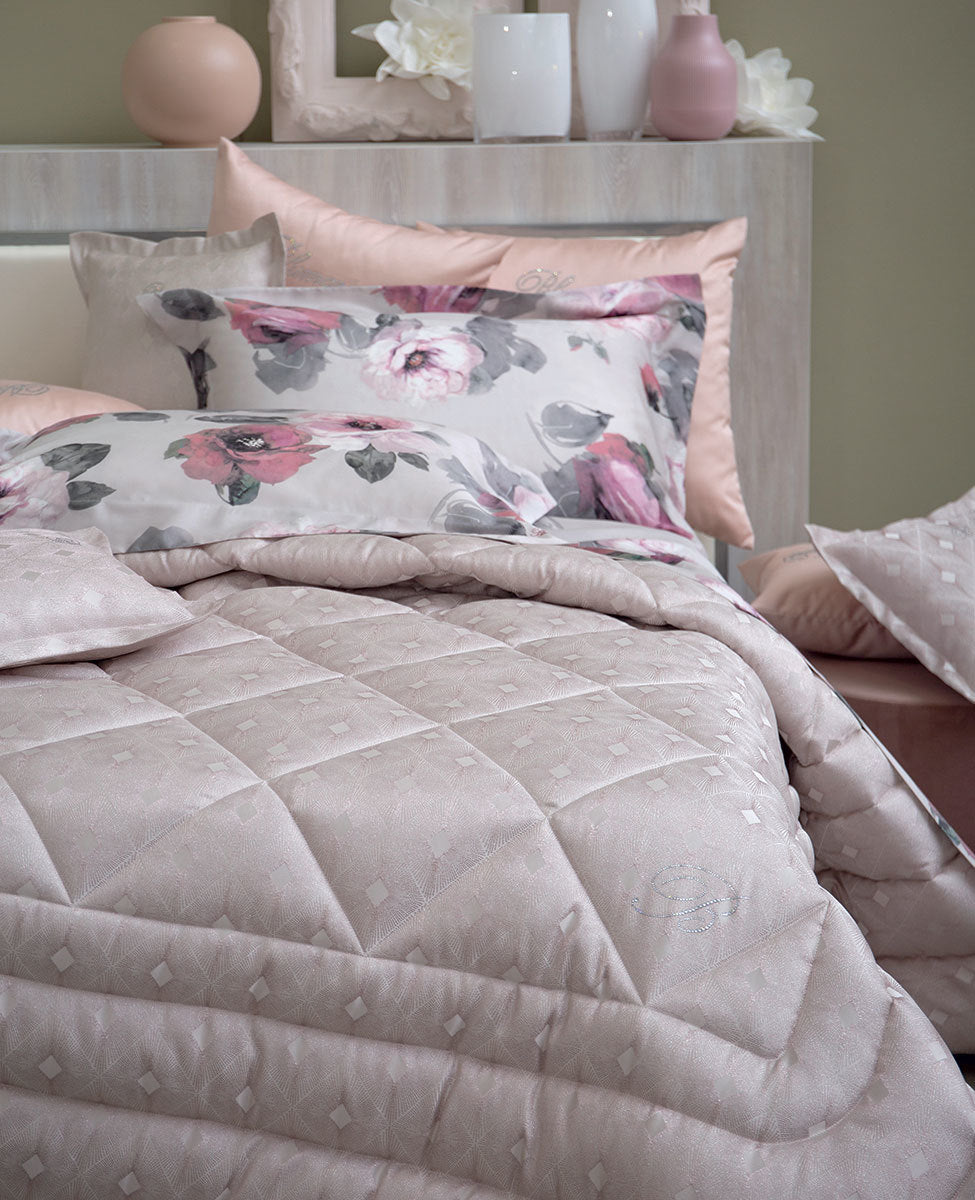 Calda trapunta matrimoniale con moderno disegno jacquard e logo Blumarine in cristalli. Misure: 270x265 cm Tessuto sopra: 100% poliestere jacquard tinto in filo Tessuto sotto: 100% cotone Imbottitura: 100% poliestere 340 g/mq Made in Italy Codice: 72619 I